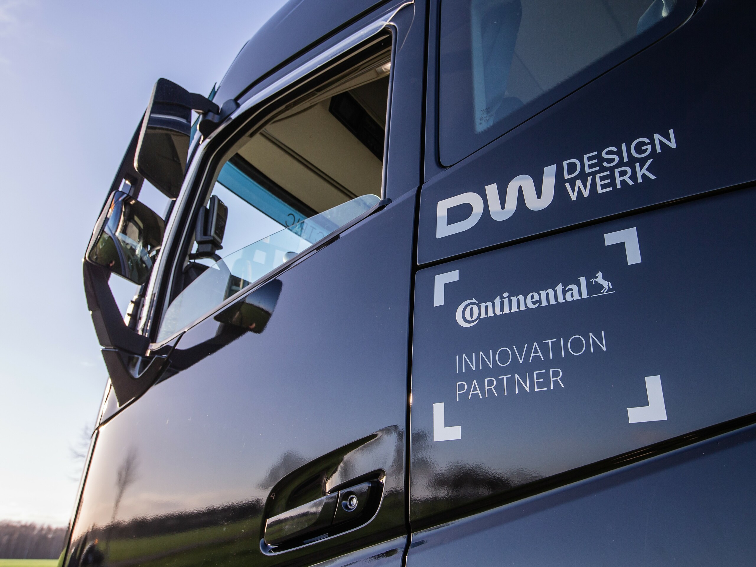 Nahaufnahme von einem E-Truck. Ersichtlich ist ein Seitenspiegel und die Logos von Continental und Designwerk.
